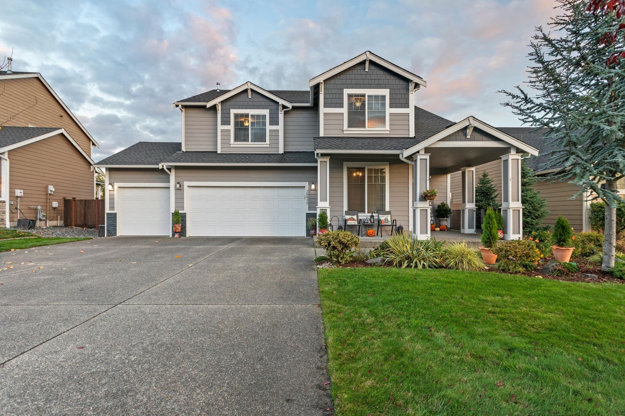 Two-story home with gray lap siding, white trim, and a covered front porch